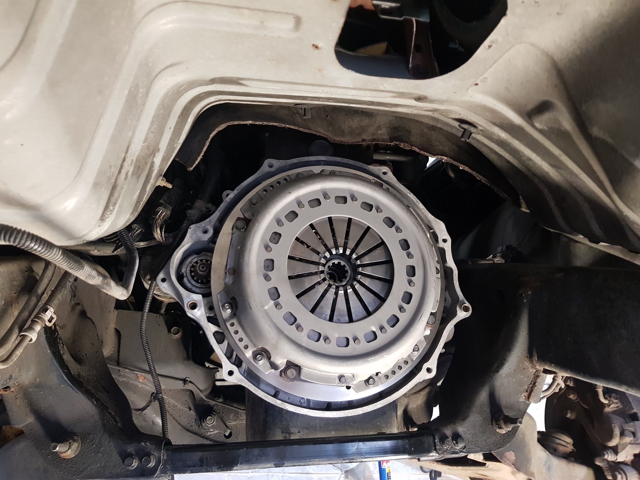 A clutch fitted to the flywheel, seen from under the car with the transmission out