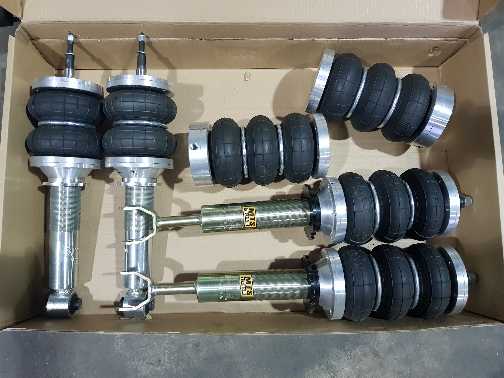 An air suspension kit in its box, air bellows on struts